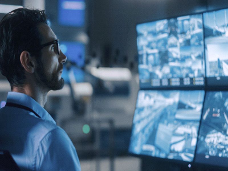 Man monitoring home security in office